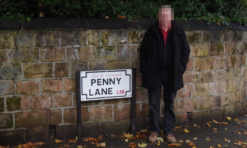 페니 레인 도로를 알리는 표지판에서 비틀즈 팬이 인증샷을 찍고 있다.