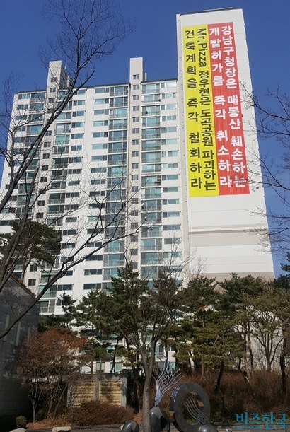미스터피자 가맹본부 MPK그룹이 정우현 회장 소유의 서울 도곡동 부지에 신사옥을 건설할 계획이다. 하지만 인근 주민들은 현수막과 대자보를 내걸고 신사옥 건설을 반대하고 있다.