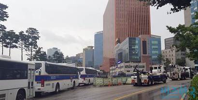 후암동 방면으로 향하는 7차선 도로의 안전지대에 불법 주차된 경찰버스와 경찰견인차.  사진=유시혁 기자