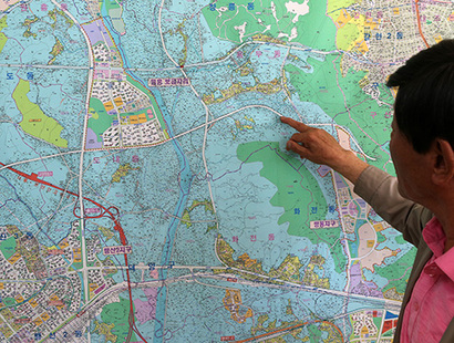 고양시 부동산 중계업자가 창릉동 일대 지도를 가리키며 수용지역을 설명하고 있다. 사진=연합뉴스
