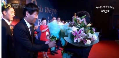2016년 IDS홀딩스 창립 9주년 행사에서 김성훈 대표(오른쪽)에게 꽃디발을 전달하는 김 아무개 베트남 법인 대표. 사진=유튜브 동영상 캡처