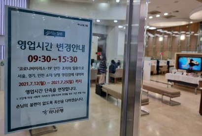 ​지난해 서울시 중구 은행에 붙은 영업시간 변경 안내문. ​은행들은 2020년부터 사회적 거리두기 시행에 따라 영업시간을 단축했다. 사진=연합뉴스