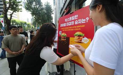 지난 17일 강남구에 위치한 롯데리아 선릉점에서 진행한 롯데리아 대표버거 라이벌전 시식회에 투표를 하고 있는 모습. 사진=롯데GRS 제공